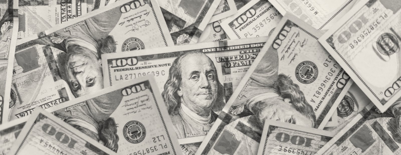 A scattered pile of one hundred dollar bills, rendered in monochrome.