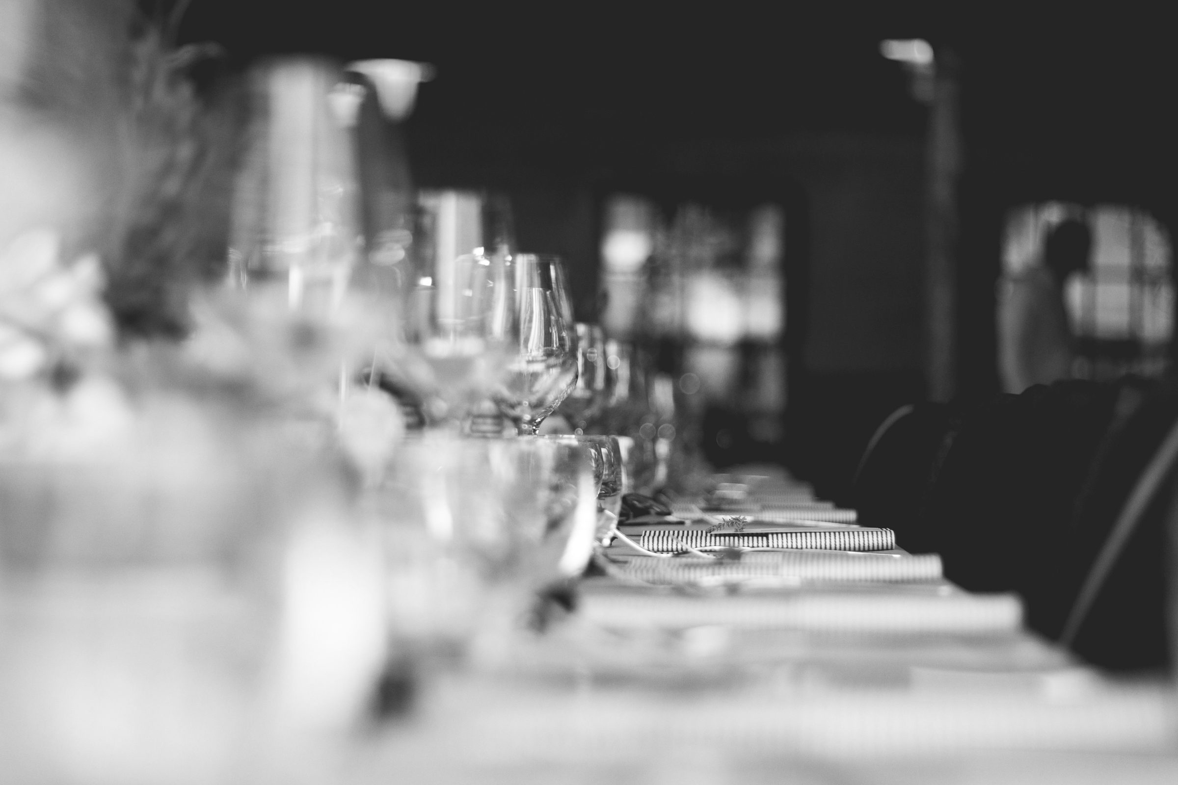 a long table set with glasses and napkins, waiting for guests